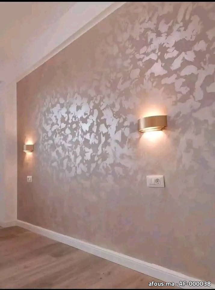 Mur en enduit décoratif nacré rose-taupe à appliques dorées — Taza