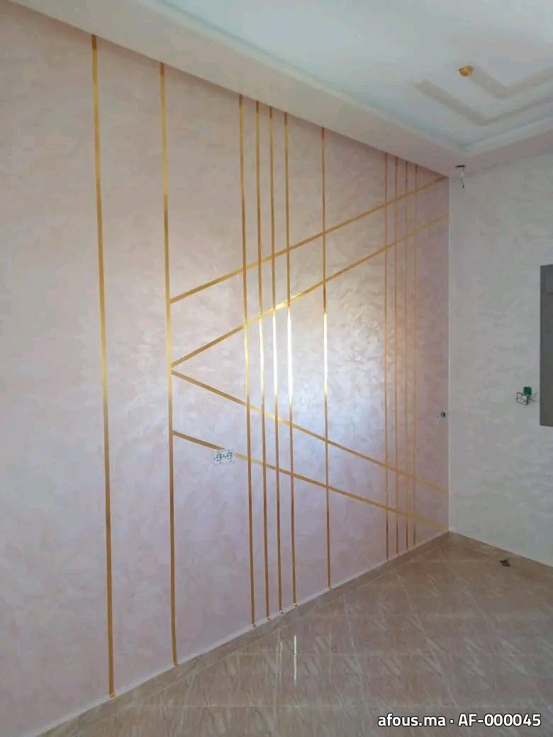 Mur en enduit décoratif nacré rose à baguettes dorées géométriques — Agadir