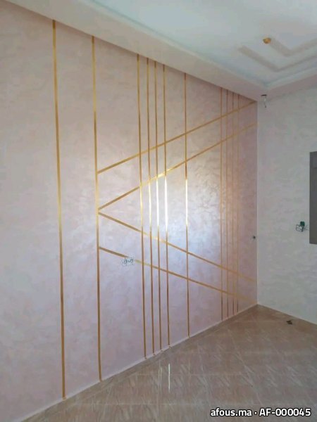 Mur en enduit décoratif nacré rose à baguettes dorées géométriques