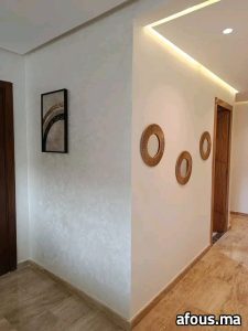 Couloir à enduit nacré blanc et miroirs ronds en rotin — Fès