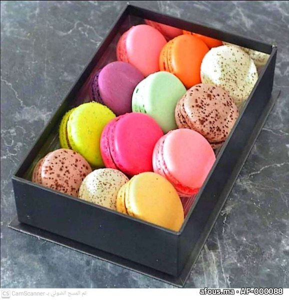 Boîte de macarons multicolores sur un plan de marbre