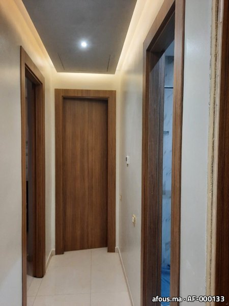 Couloir à portes en bois de noyer et faux plafond