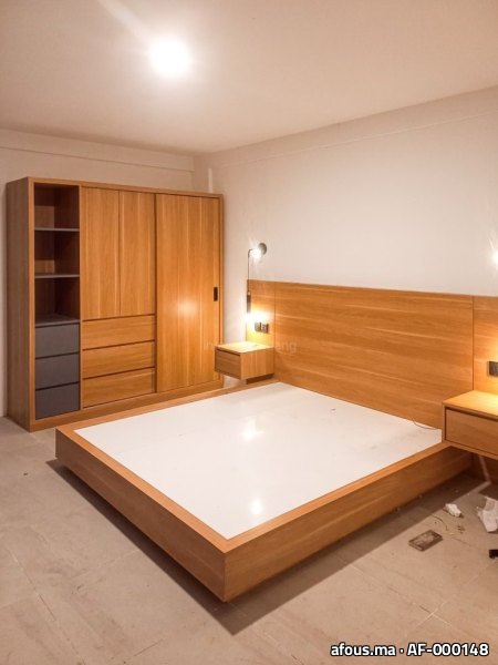 Chambre à coucher en bois avec lit, tête de lit, armoire et chevet