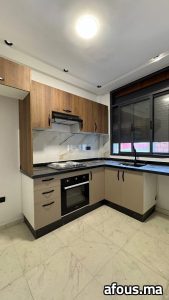 Cuisine en L effet bois et taupe avec plan en granit noir — Tanger