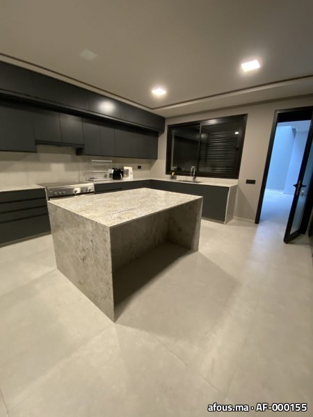 Cuisine laquée noire avec îlot en granit clair
