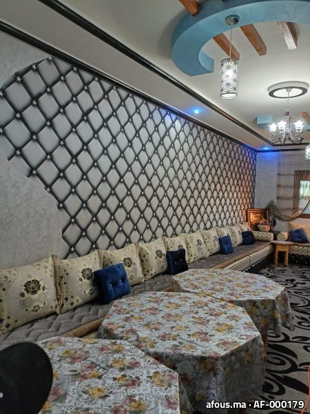Salon marocain à mur capitonné rétro-éclairé et faux plafond à poutres