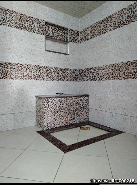 Hammam habillé de mosaïque beige et marron avec banquette