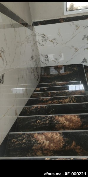 Escalier habillé de carrelage effet marbre blanc et noir doré