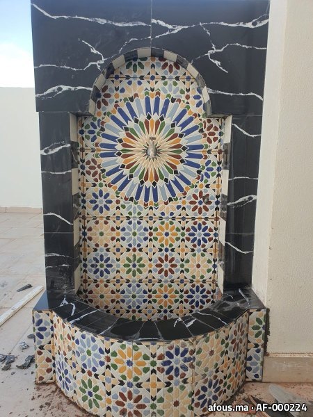 Fontaine murale en zellige à rosace polychrome encadrée de marbre noir