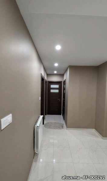 Couloir peint taupe avec portes en bois foncé et sol