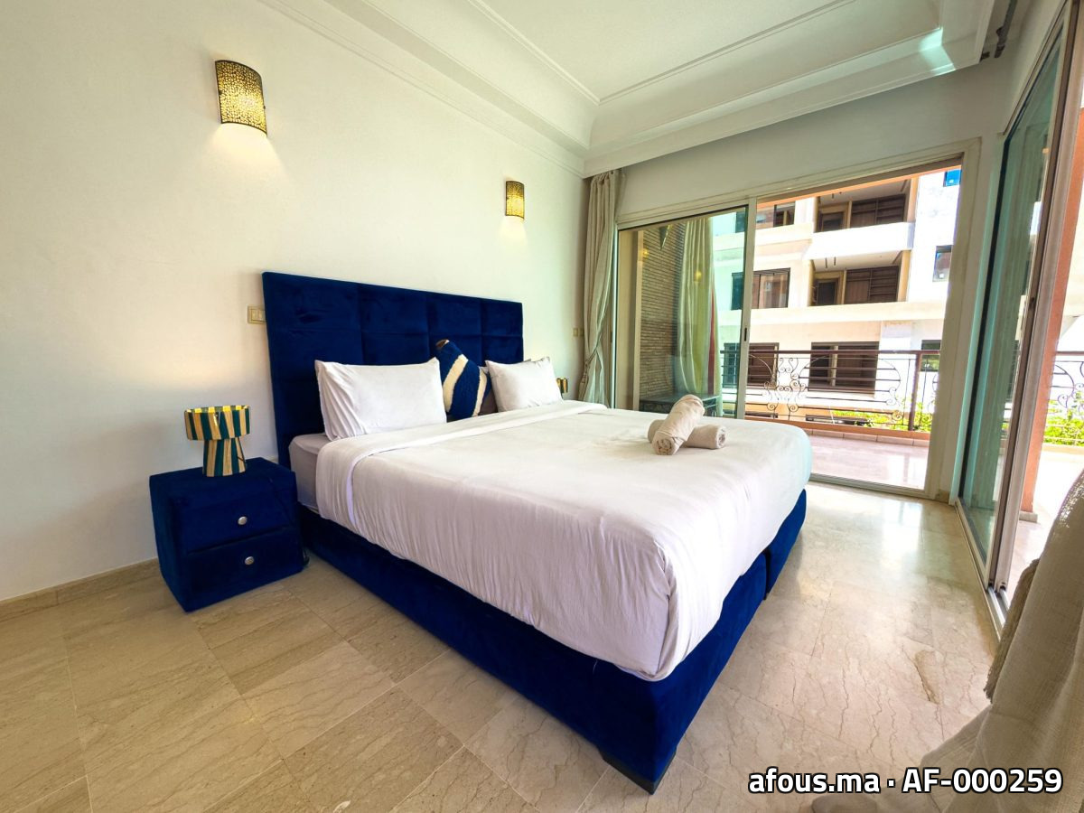 Chambre à tête de lit capitonnée bleu nuit et appliques dorées — Marrakech