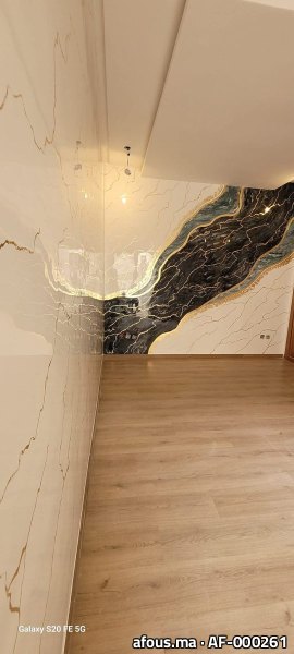 Mur en dalles effet marbre blanc à coulée noire et dorée