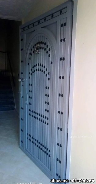 Porte d'entrée en acier gris à décor de clous