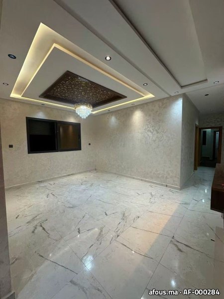 Salon avec faux plafond lumineux, panneau ajouré et lustre