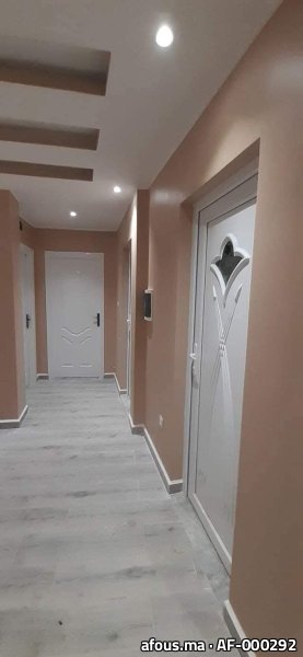 Couloir peint en tons taupe à portes blanches