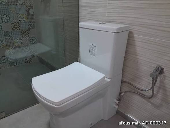 WC à poser avec douchette hygiénique dans une salle d'eau carrelée — Meknès