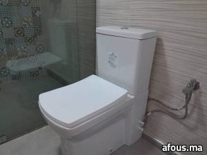 WC à poser avec douchette hygiénique dans une salle d'eau carrelée — Meknès