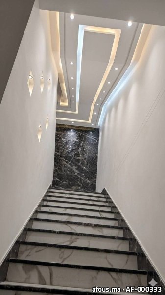 Cage d'escalier à faux plafond étagé et appliques