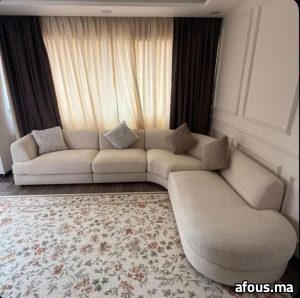 Canapé d'angle courbe beige sur tapis fleuri — Settat