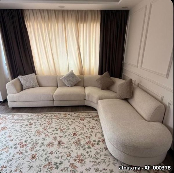 Canapé d'angle courbe beige sur tapis fleuri