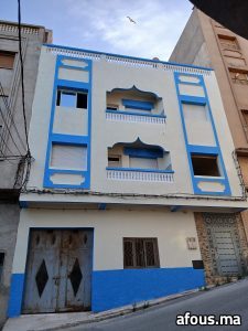 Façade peinte en crème et bleu à arcs décoratifs — Al Hoceïma