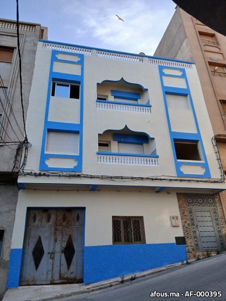 Façade peinte en crème et bleu à arcs décoratifs