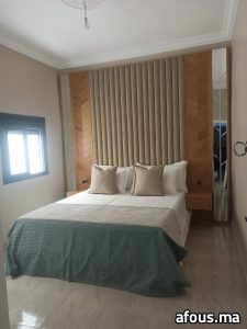 Chambre à tête de lit capitonnée et panneaux bois — Marrakech