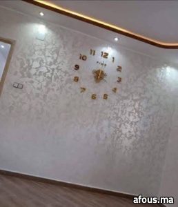Mur en enduit décoratif nacré crème à horloge dorée — Tanger