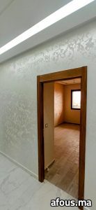 Mur en enduit décoratif gris nacré à porte bois — Meknès