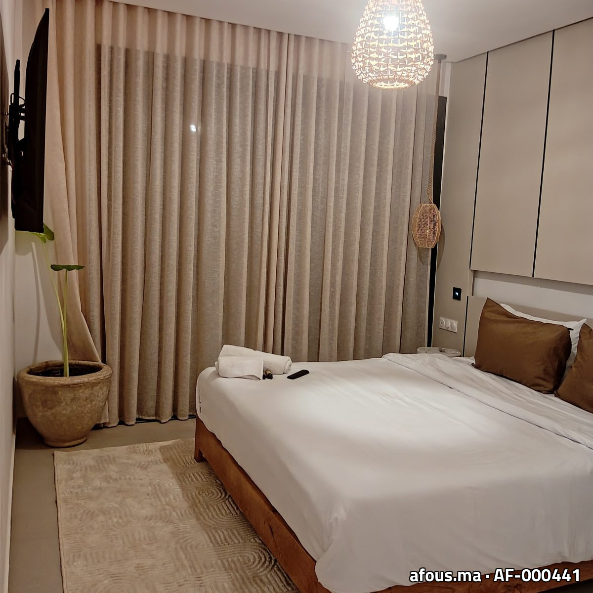 Chambre à rideaux à vagues beige et suspension rotin — Marrakech