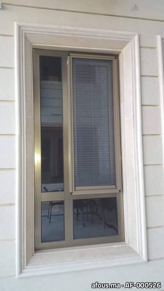 Fenêtre aluminium bronze à store intégré et chambranle en pierre