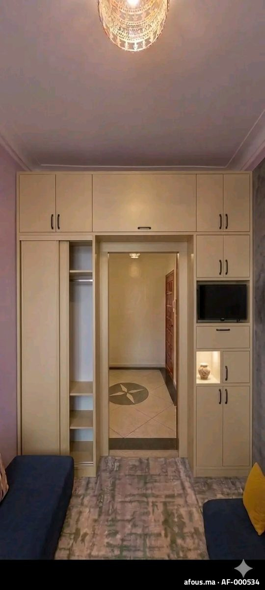Rangements sur mesure beige encadrant un passage, avec niche TV — Casablanca