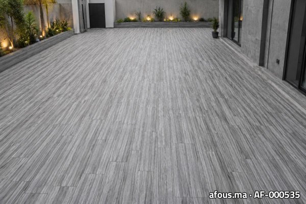 Grande terrasse pavée de marbre gris veiné avec éclairage et jardinières