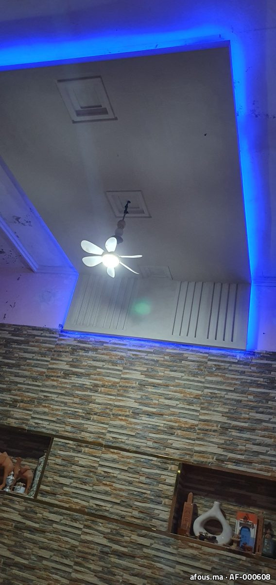 Faux plafond rétroéclairé bleu et mur en pierre — Salé